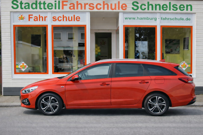 Roter Kombi vor der Fahrschule "Stadtteil Fahrschule Schneisen".